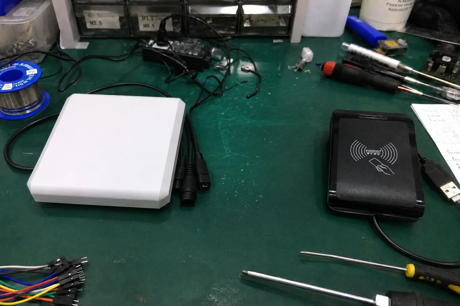 Fongwah integrated UHF RFID reader antenna and desktop USB card reader on a hardware engineering workbench.