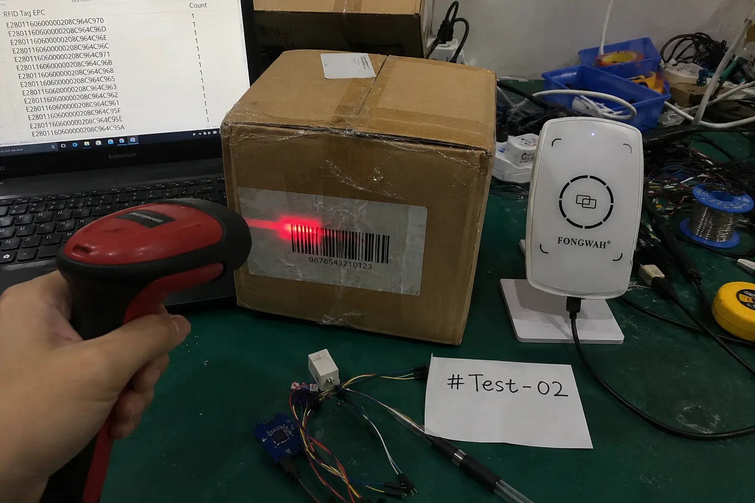 Side-by-side comparison of an optical barcode scanner gun and a Fongwah RFID reader on an inspection desk.