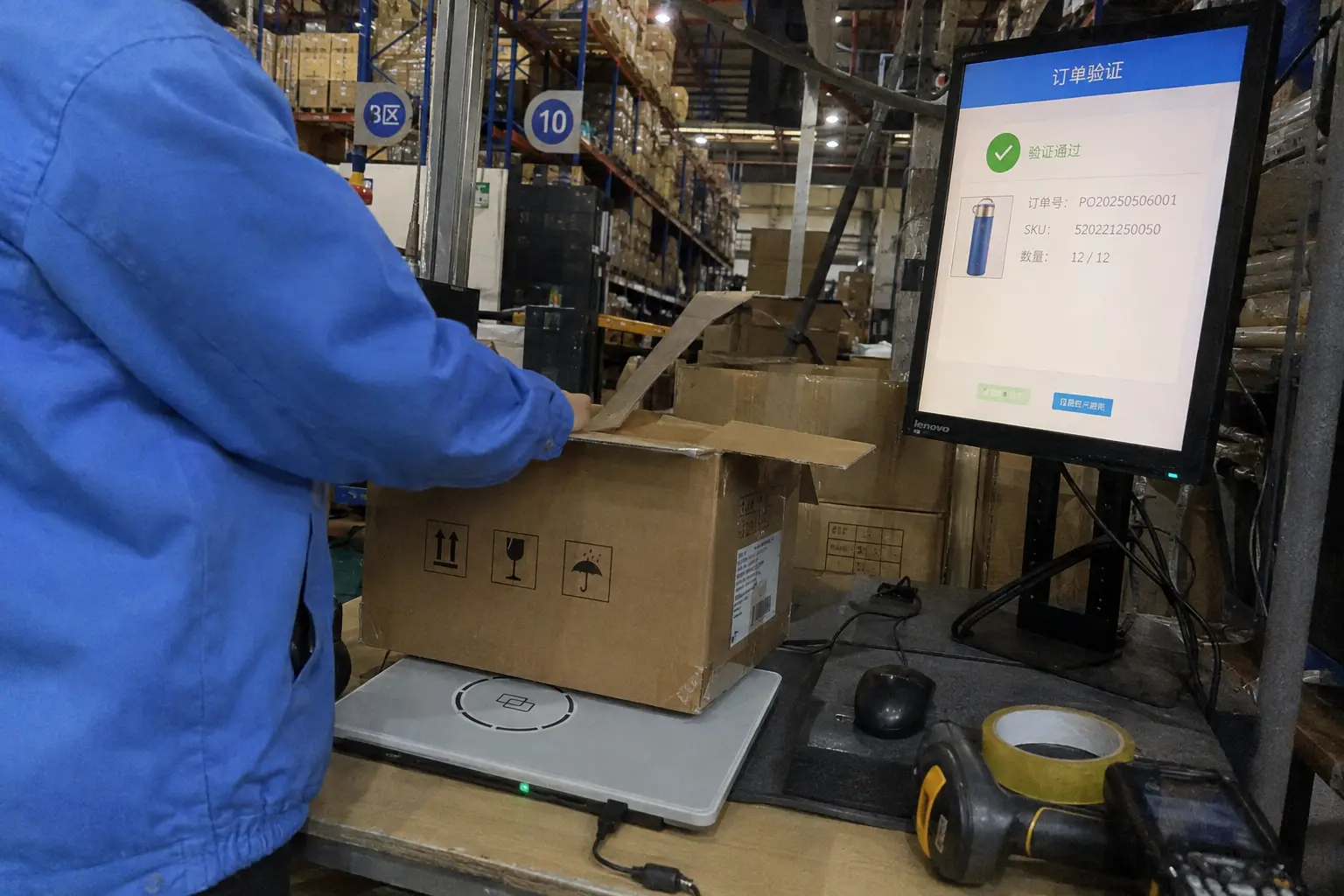 Warehouse worker using a Fongwah RFID reader at a packing station to verify carton contents against orders.