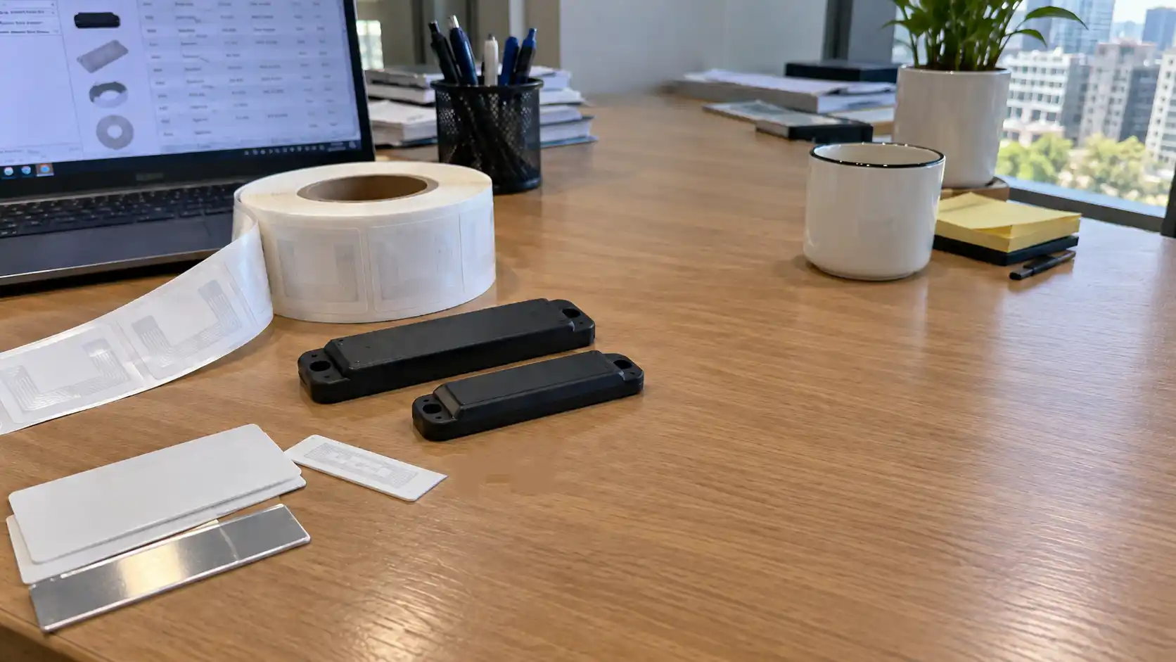 Procurement manager's desk with assorted RFID tag samples, specification sheets, and a quotation manifest.