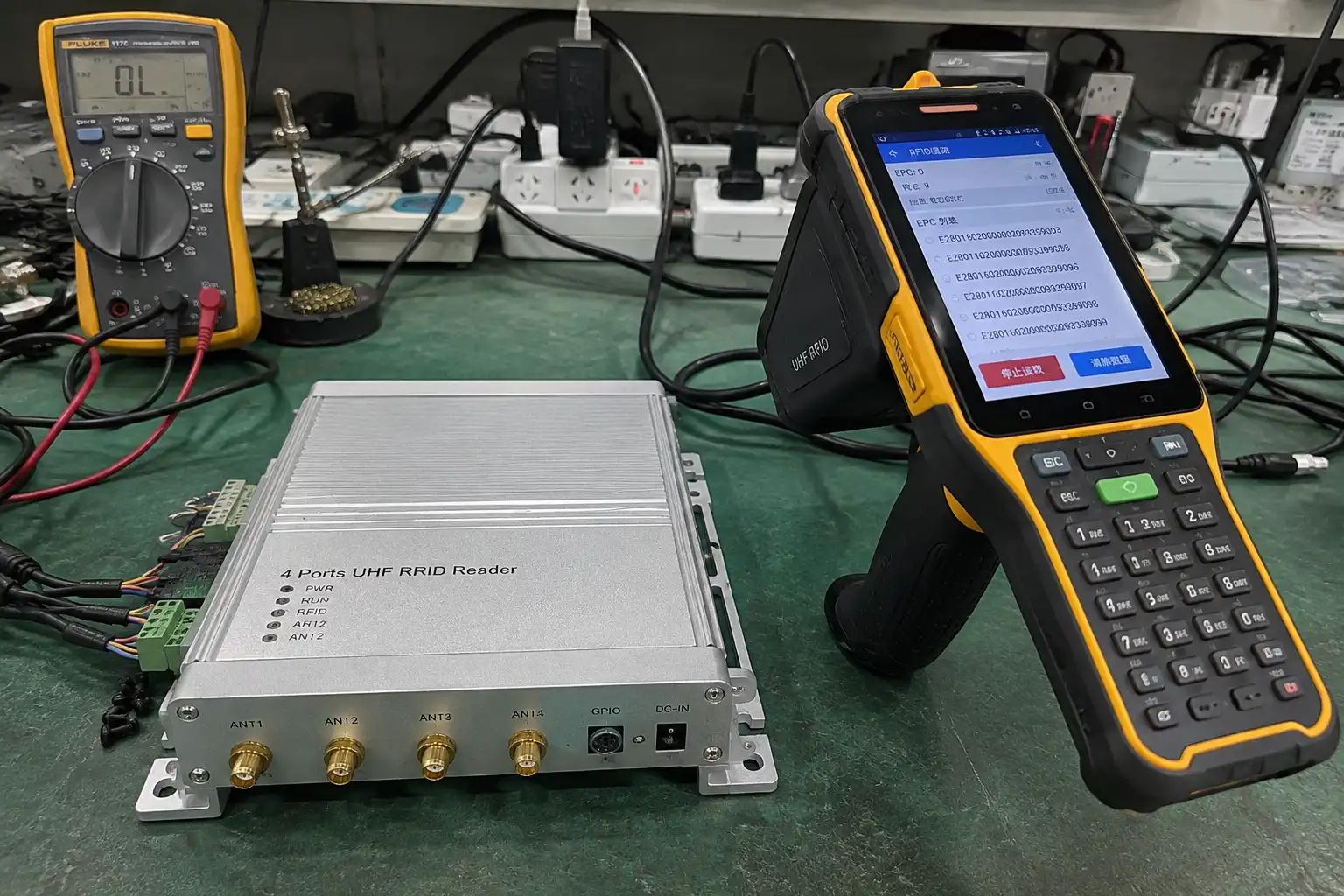 A fixed RFID reader with multiple antennas mounted on a portal, and a person holding a handheld RFID reader in a warehouse aisle.