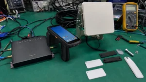 Complete Fongwah RFID asset tracking ecosystem with industrial fixed readers, handheld terminals, antennas, and on-metal tags on a test bench.