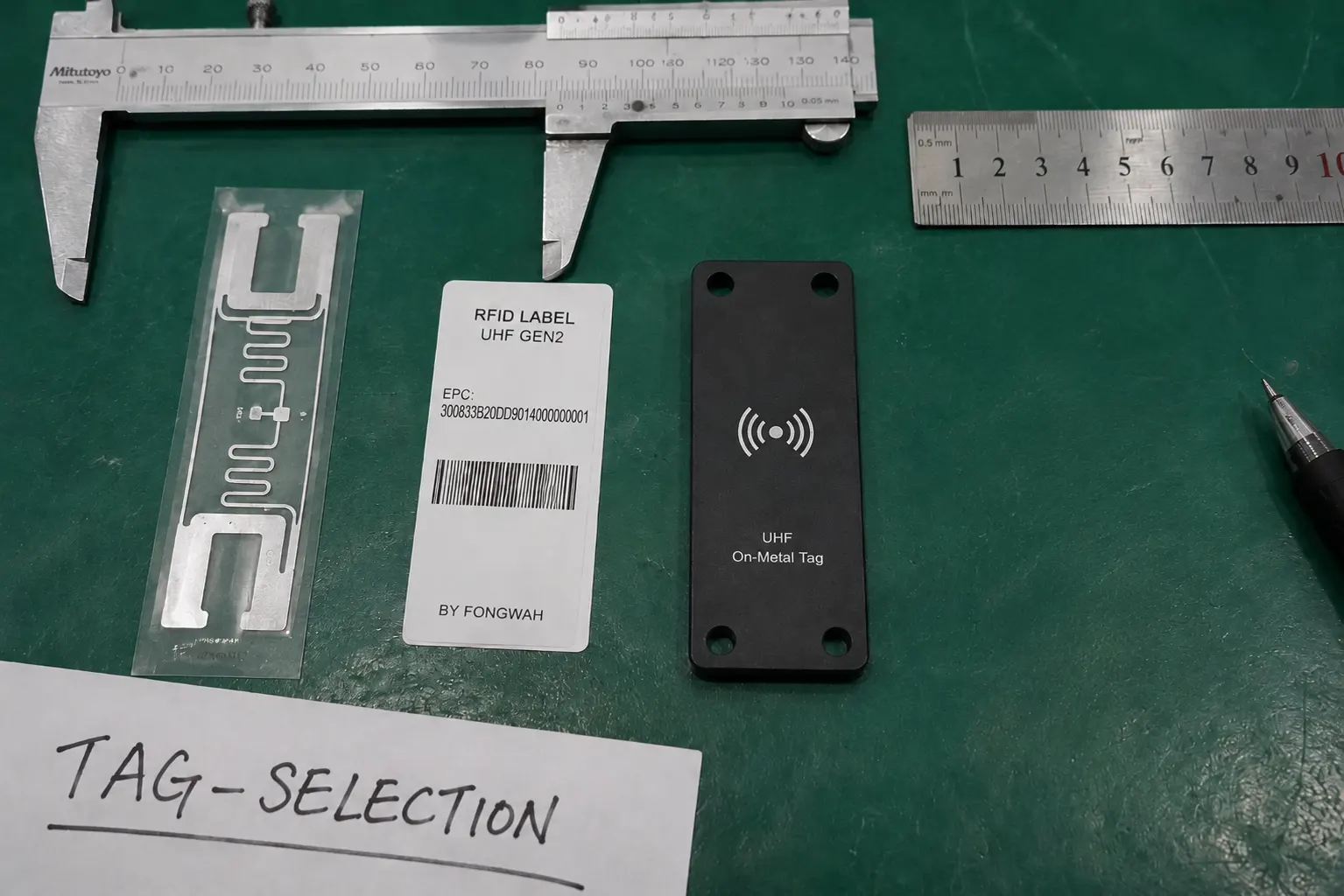 A close-up shot of various RFID tags: a hard tag for assets, a flexible label, and a small inlay.