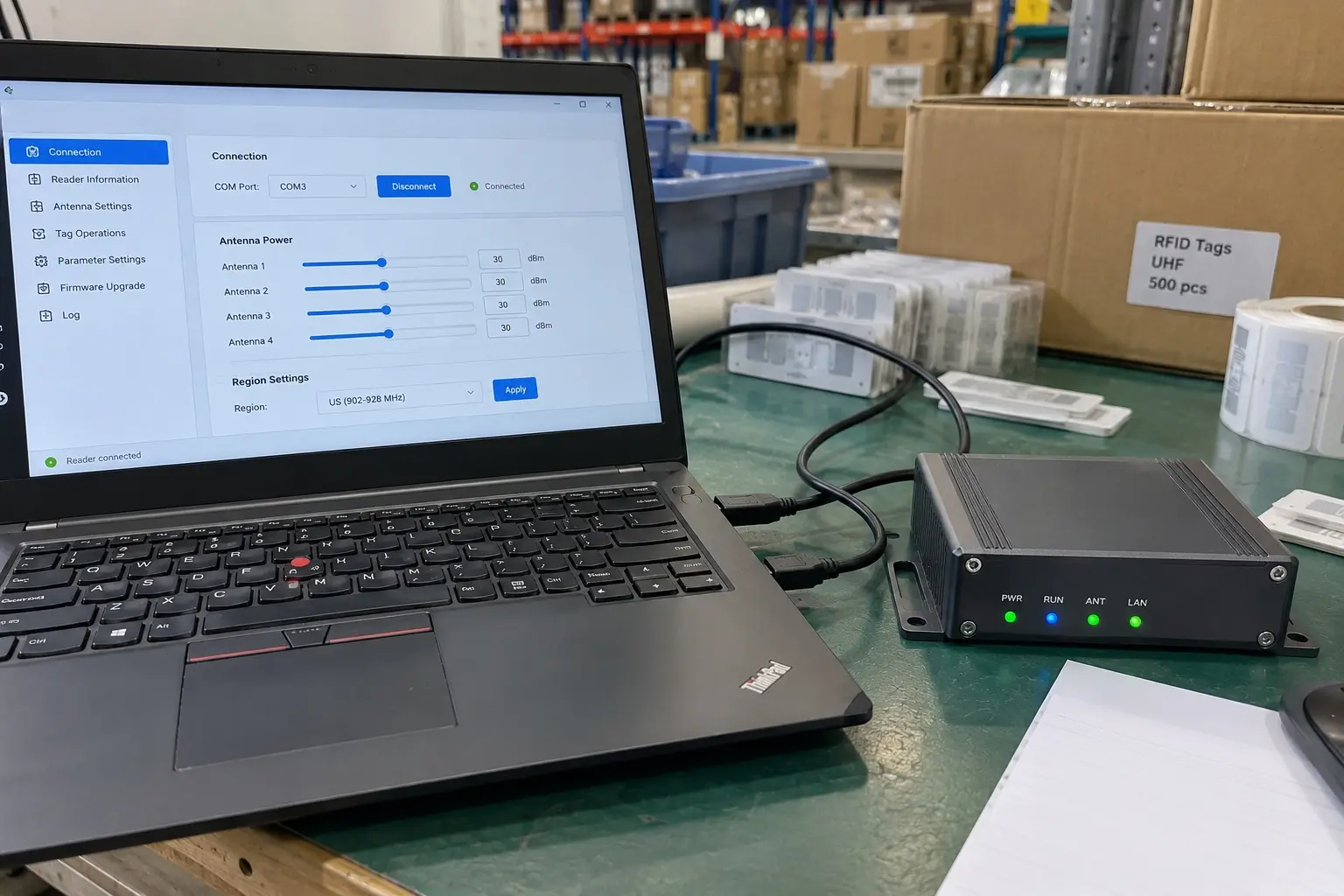 A laptop connected to an RFID reader with a USB cable