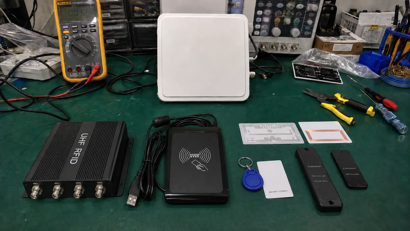 Comprehensive Fongwah RFID system setup showing tags, readers, and antennas on an engineering workbench.