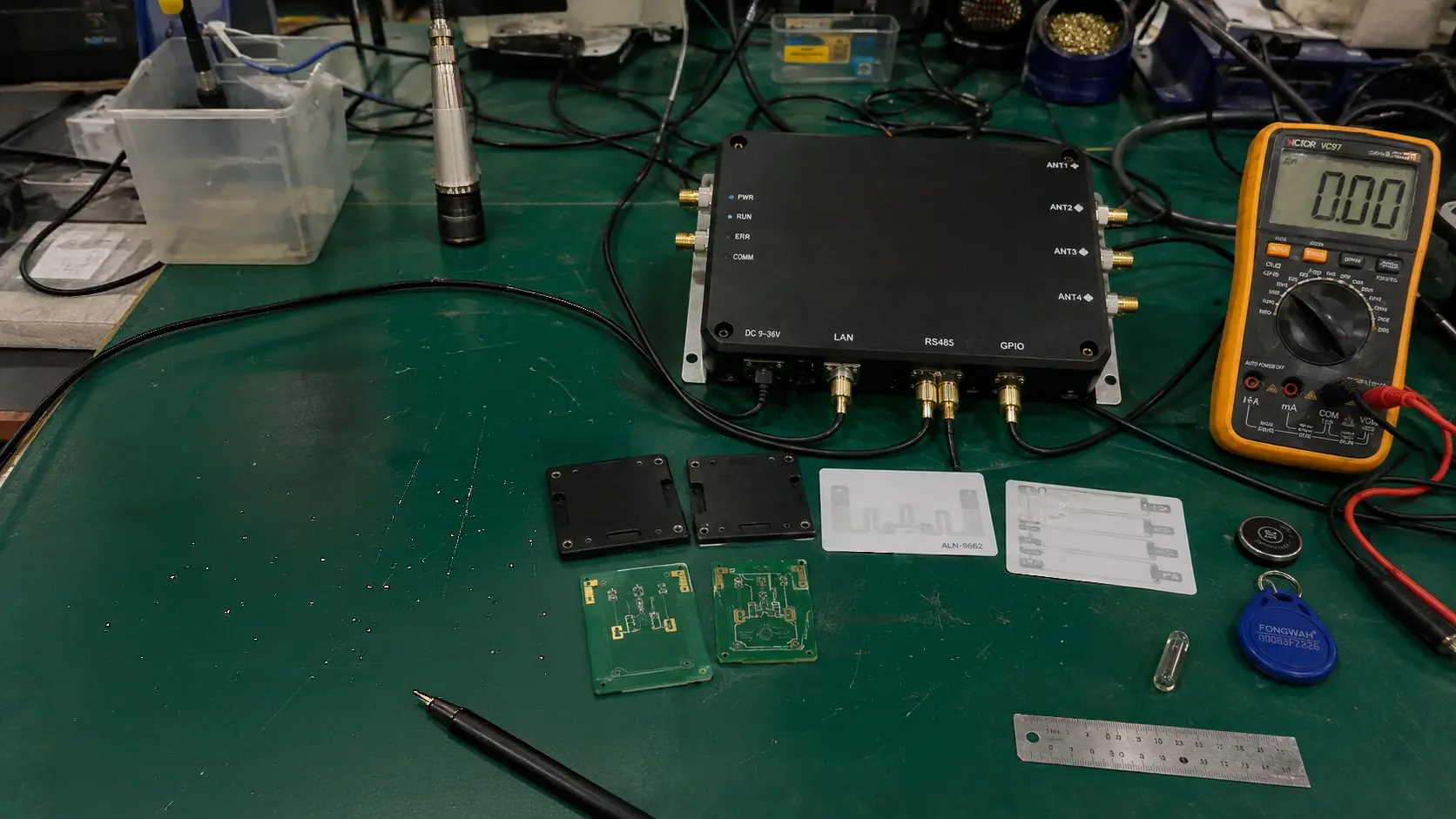 Fongwah engineering site survey setup with handheld readers, spectrum analyzer, and RFID tags on an industrial test bench.