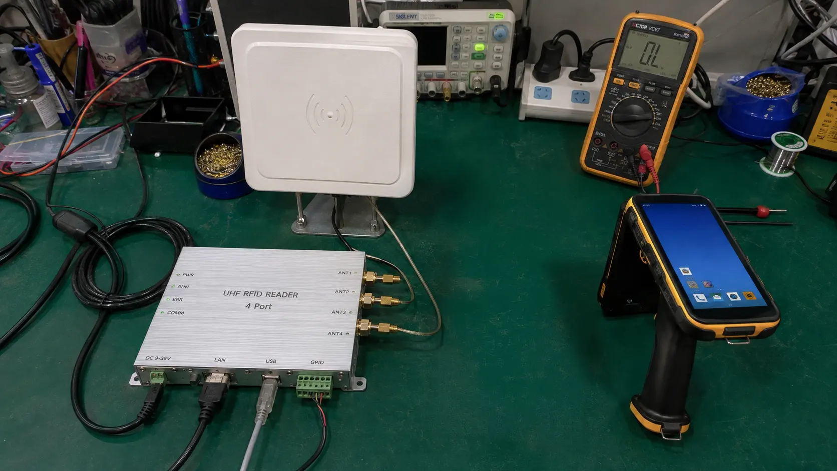 Comprehensive comparison setup of Fongwah fixed 4-port UHF RFID reader modules and rugged handheld terminals on an engineering test bench.