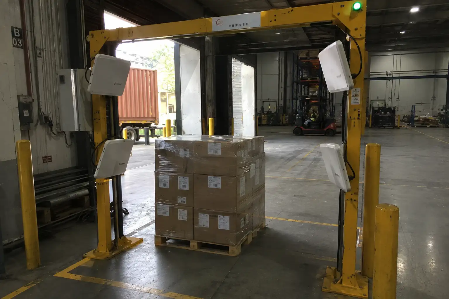 Fongwah UHF RFID dock door portal setup scanning tagged pallets in an industrial logistics warehouse.