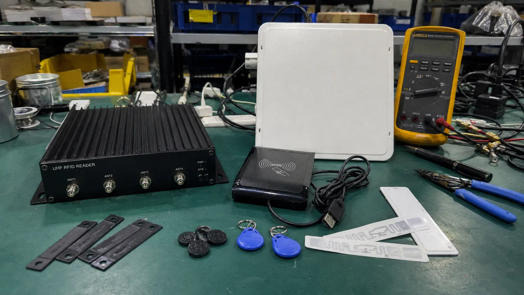 Fongwah comprehensive RFID technology showcase with industrial UHF tags, fixed readers, and patch antennas on a test bench.