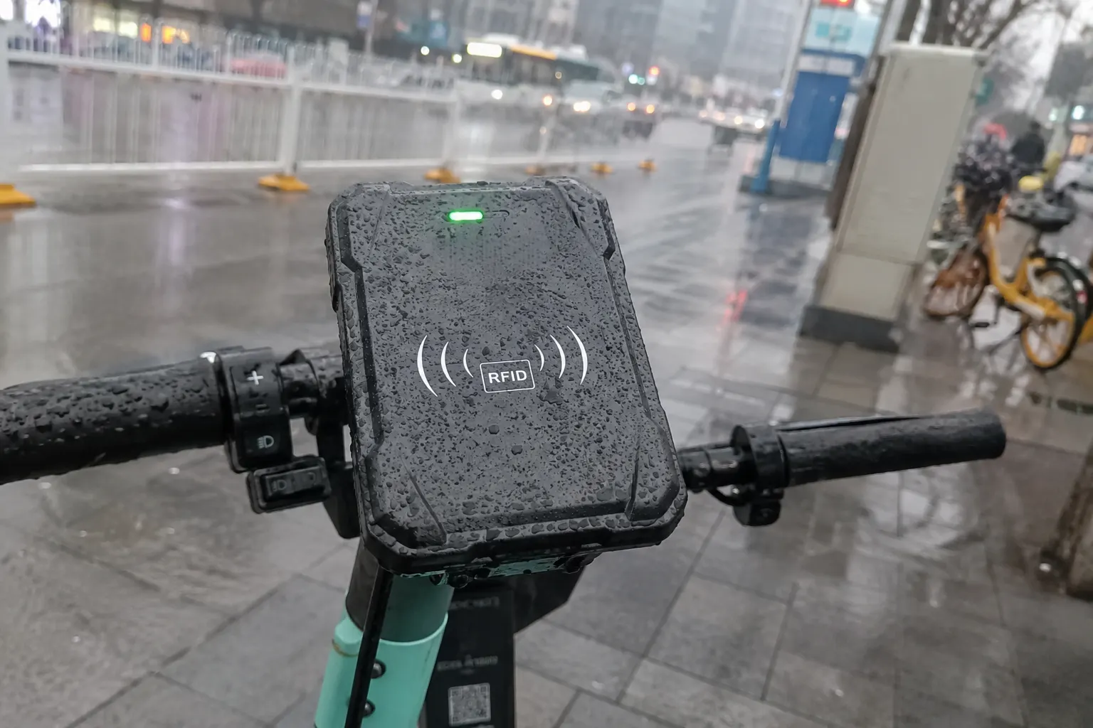 An e-scooter with a rugged, weatherproof RFID reader on the handlebar in a rainy urban setting