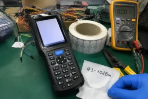 Fongwah handheld RFID reader performing high-density retail bulk encoding diagnostics on a messy Shenzhen hardware lab workbench