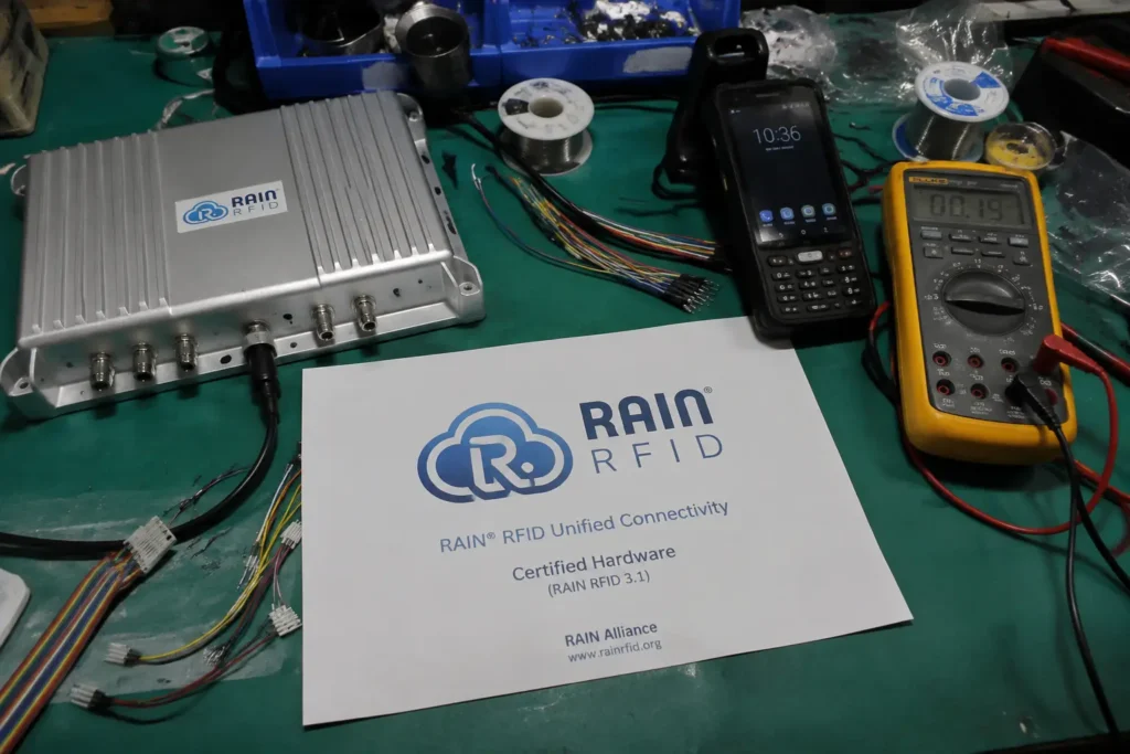 Fongwah technical team examining global standard RAIN RFID passive hardware on a messy engineering lab mat