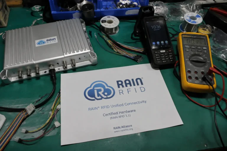 Fongwah technical team examining global standard RAIN RFID passive hardware on a messy engineering lab mat